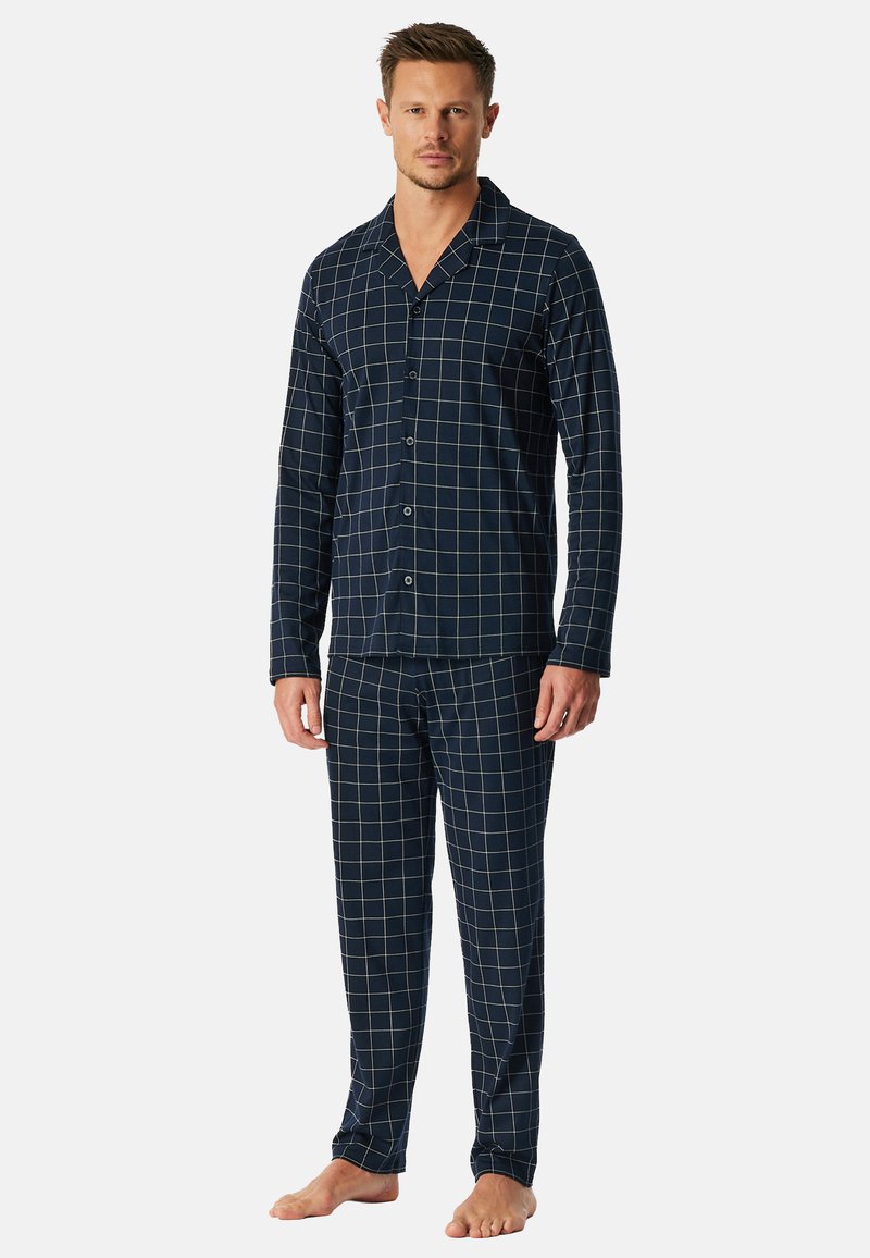 Conjunto de pijama de algodón azul marino con un patrón de cuadrícula blanca, que incluye una camisa con botones y pantalones con cintura elástica. Textura suave, ajuste relajado.