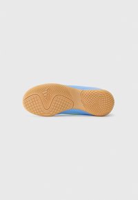 Sola di scarpe sportive multicolore con un motivo in gomma testurizzata. Presenta tonalità di blu e verde, con logo di marca ben visibile.