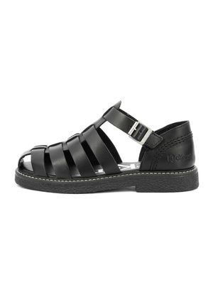 Black leather fisherman sandal with ankle strap, silver buckle, textured sole, and brand name "Kickers" embossed on heel.