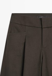 Donkerbruine broek met een gladde textuur, voorzien van een platte tailleband, zijzakken en een enkele voorvouw voor een tailored uitstraling.