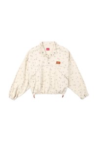 Veste pullover beige clair avec un motif discret de flocons de neige. Elle dispose d'une patte à pressions, de poignets élastiques et d'un ourlet ajustable avec des accents orange.