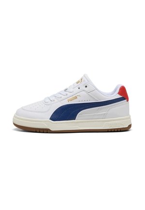 Sneaker bianca Puma con striscia blu laterale, linguetta rossa sul tallone, logo dorato, design con lacci e suola beige con battistrada marrone.