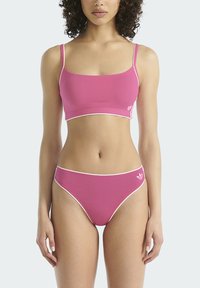 Roze bikiniset met een cropped top met dunne bandjes en een broekje met hoge taille, beide voorzien van witte bies en een logo aan de zijkant.