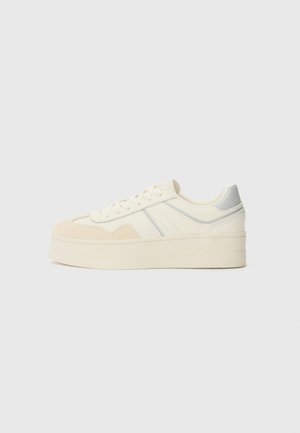 Cremfarbene Sneaker mit strukturierten beigen Wildlederakzenten, hellblauen Details und einer dicken weißen Sohle. Klassisches Schnürdesign.