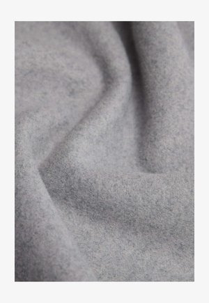 Tela gris claro con una superficie suave y texturada, que exhibe tonos sutiles y un acabado liso y no reflectante, arreglada en pliegues.