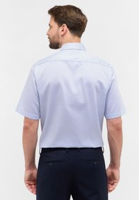 Kurzarmhemd in Hellblau mit subtilen geometrischen Mustern, aus glattem Stoff gefertigt. Verfügt über einen klassischen Kragen und eine lockere Passform.