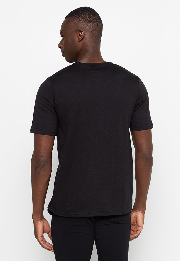 T-shirt noir à manches courtes en coton, avec un col rond et une coupe standard. Design plain sans motifs ni accents.