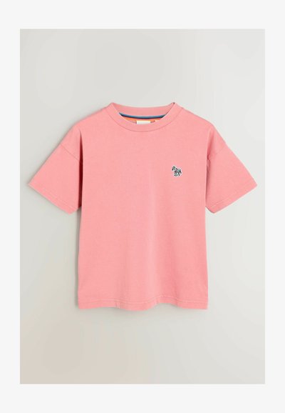 Rozā kokvilnas t-krekls ar īsām piedurknēm, kuram ir mazs, daudzkrāsains zebras izšuvums uz kreisās krūtis. Apaļš kakls, brīva piegriezuma.