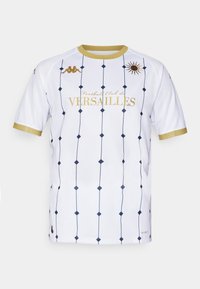 Vit tröja med marinblå diamantmönster, guldaccenter och "Football Club de VERSAILLES" i guldtext. Korta ärmar och rund halsringning.