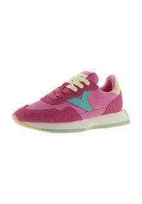 Zapatilla deportiva de color rosa y magenta con detalle en azul verdoso, cordones crema y suela gruesa de color blanco roto con acento azul verdoso, inclinada hacia la izquierda sobre fondo blanco.