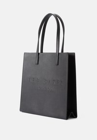 Bolso tote negro con textura de cuero sintético, logotipo en relieve "TED BAKER LONDON" y dos asas resistentes. Forma rectangular, diseño minimalista.