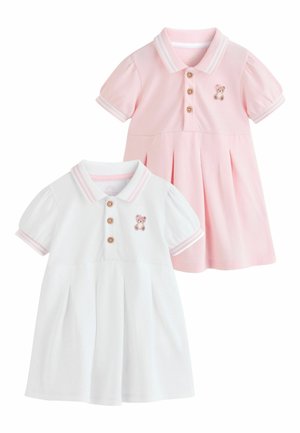 Dve krátke detské šaty s krátkym rukávom, jedna ružová a jedna biela, každá s drevenými gombíkmi, golierom a malou výšivkou medvedíka na hrudníku.