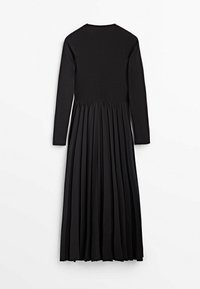 Robe noire longue, avec un haut ajusté et une jupe plissée et fluide. Fabriquée dans un tissu doux avec un col rond et des manches longues.