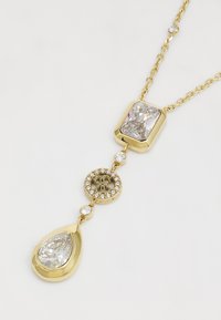 Collana in oro con ciondolo rettangolare contenente un gemma trasparente, un ciondolo circolare decorato con gemme più piccole, e una gemma trasparente a forma di goccia.
