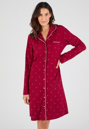 Camicia da notte rossa in cotone con motivo a stelle bianche, maniche lunghe, chiusura con bottoni frontale, colletto a punta e taschino sul petto con dettagli a bordo.
