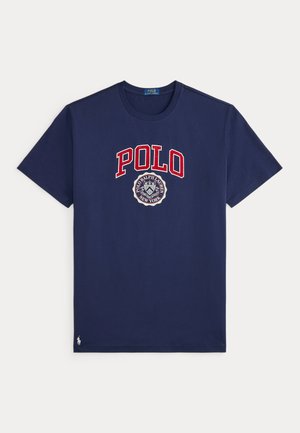 Navy blue short-sleeve T-shirt with red "POLO" text and a circular Polo Ralph Lauren emblem in white and blue on the front center.