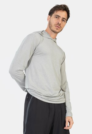 Lichtgrijze lange mouwen hoodie met een gestructureerd oppervlak en een verstelbare capuchon, gecombineerd met loszittende zwarte sportshorts.