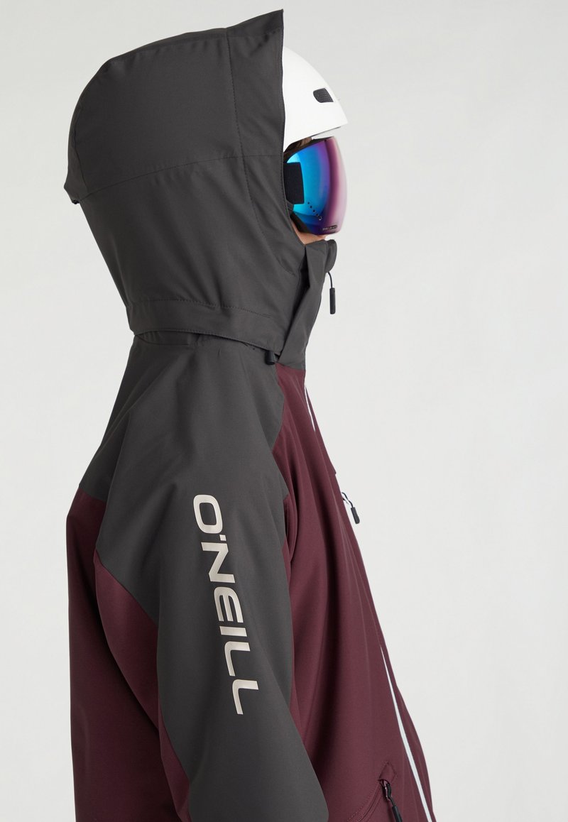 Skijacke in Bordeaux und Dunkelgrau, ausgestattet mit einer Kapuze, Taschen mit Reißverschluss und einem weißen Markenlogo auf dem Ärmel. Glattes, wetterbeständiges Material.