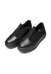 Zapatos negros sin cordones con un exterior de ante texturizado y una puntera de cuero, que cuentan con paneles laterales elásticos y una suela de goma gruesa y con patrón.
