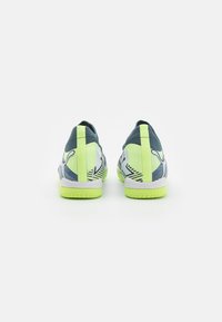 Scarpe sportive con tomaia in rete blu e accenti gialli, caratterizzate da una superficie testurizzata, strisce a contrasto e una suola spessa verde.