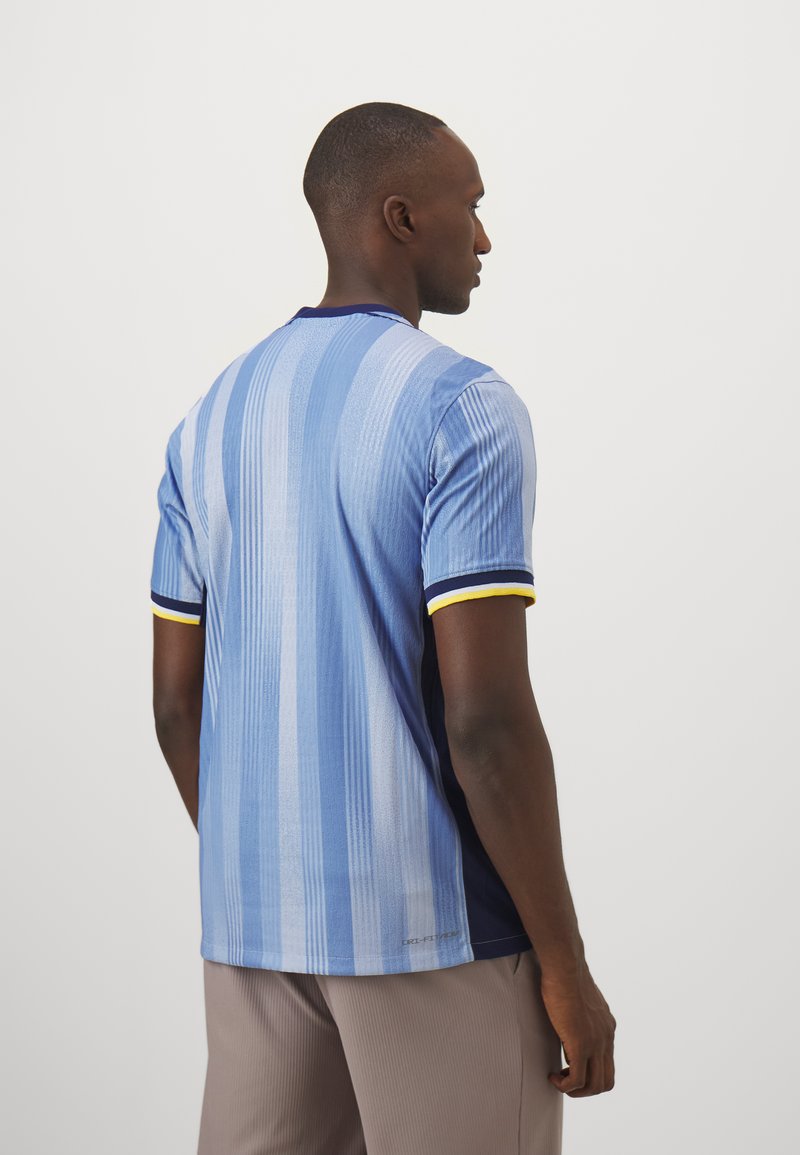 Jasnoniebieska koszula z krótkim rękawem w paski, z granatowymi bokami, żółtymi akcentami na rękawach oraz teksturowanym materiałem. Zaprojektowana w dopasowanym kroju.