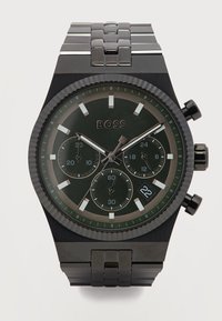 Ρολόι χεριού χρονογράφου σε μαύρο μέταλλο με συνδεδεμένο βραχιόλι, τρεις υποκαντράν, παράθυρο ημερομηνίας στη θέση 4 η ώρα και λογότυπο "BOSS" στο καντράν.