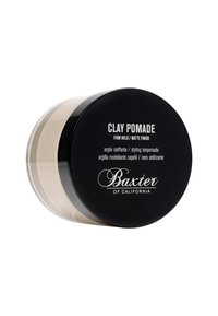 Zwarte ronde container met het label "Clay Pomade" in witte tekst. Transparante basis die de crèmekleurige pomade binnenin onthult. Stevige hold, matte afwerking.