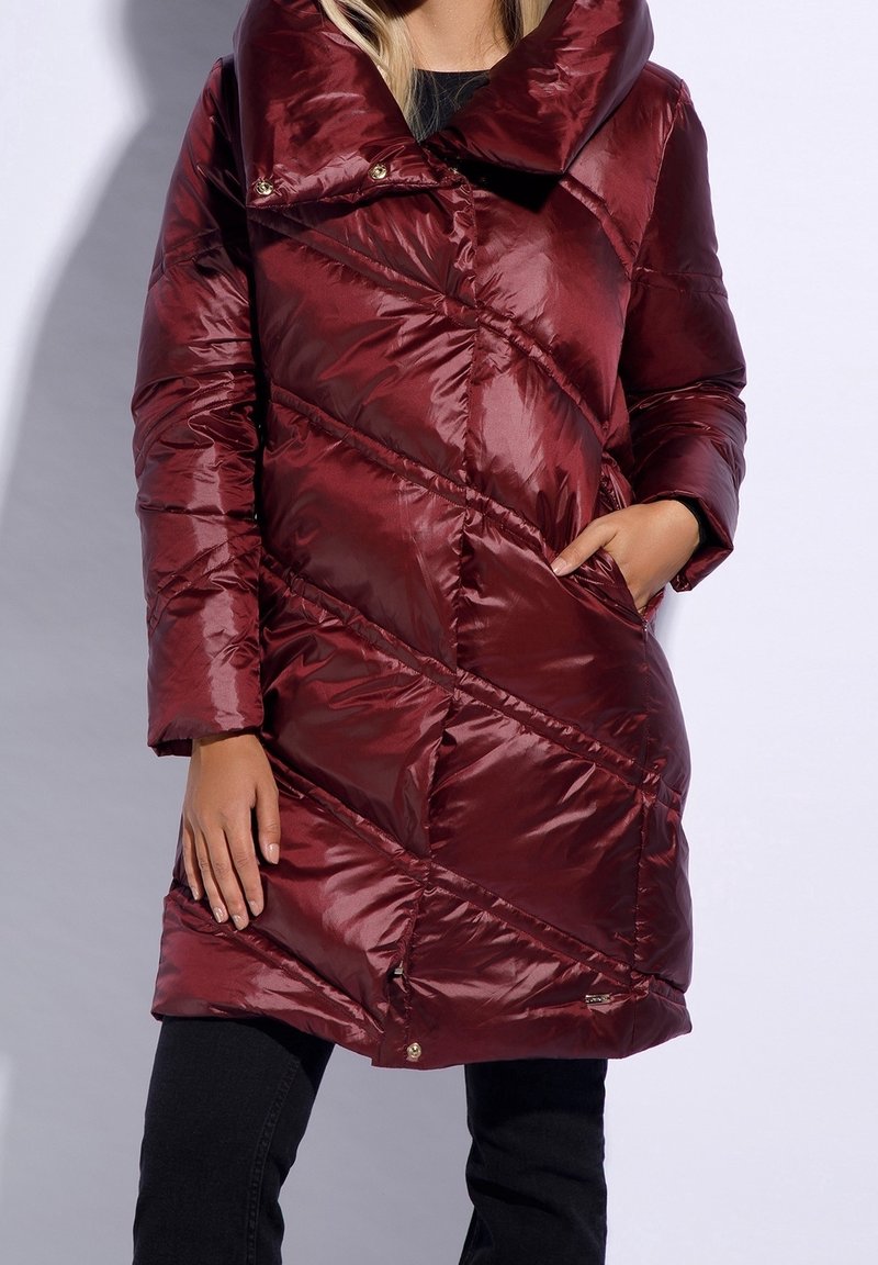 Manteau rembourré bordeaux avec un large col, un design en diagonale de piquage et des poches latérales. Texture brillante et accents en métal doré.