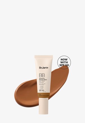 Tube de Dr.Jart+ BB Premium Beauty Balm avec SPF 50 en teinte beige, placé sur un tourbillon de la couleur du produit sur fond blanc.