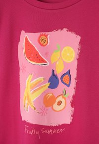 Tissu rose vif avec des illustrations colorées de fruits, comprenant pastèque, bananes, citrons, figues, pêche et grenade, avec le texte « Été fruité » en dessous.