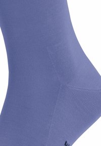 Calzino blu chiaro realizzato in un materiale morbido e elastico con una trama a costine e punta rinforzata, con logo nero sulla suola.