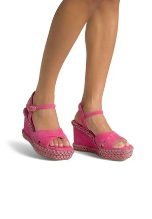 Sandali con zeppa in suede rosa, con fascia incrociata e cinturino alla caviglia. Dettaglio intrecciato sulla piattaforma che aggiunge consistenza.