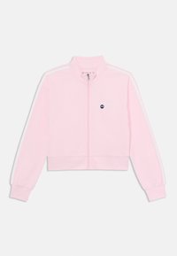 Lyserød cropped zip-up jakke lavet af blødt stof, med hvide side-striber, en høj krave og et lille logo på fronten.