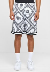 Black and white patterned shorts featuring a bandana design, with a black trim along the hem, made from lightweight fabric.