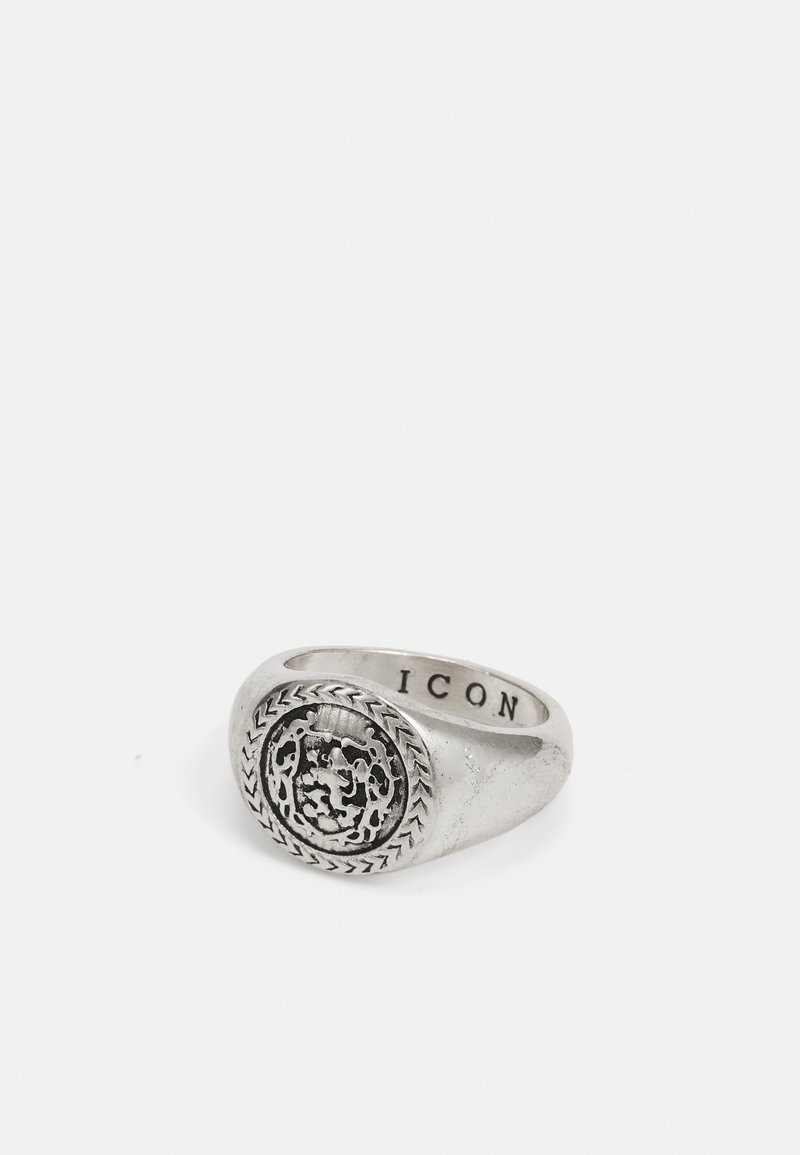 Silver signet ring with a textured circular face featuring an ornate design. "ICON" engraved on the inside. Smooth exterior finish.