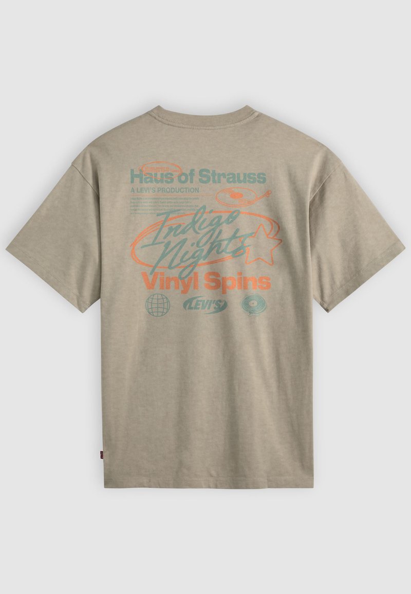 T-shirt beige avec des graphismes bleu sarcelle et orange indiquant "Haus of Strauss", "Indigo Nights", "Vinyl Spins", ainsi que de petites icônes de disques vinyles et de globe à l'arrière.
