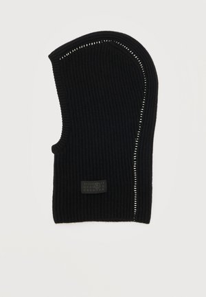 Svart ribbad stickad balaklava med vit sydd detalj längs kanterna och en liten rektangulär logotypmärke nära botten.