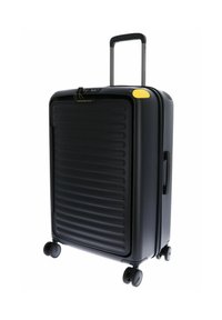 Valise rigide noire avec des rainures verticales, poignée rétractable, quatre roues et accent jaune près du haut. Dispose d'un verrou à combinaison approuvé par la TSA.