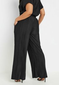 Svarta plisserade vida byxor med hög midja och sidofickor. Mjuk textur och flödande design, lämpliga för olika tillfällen.