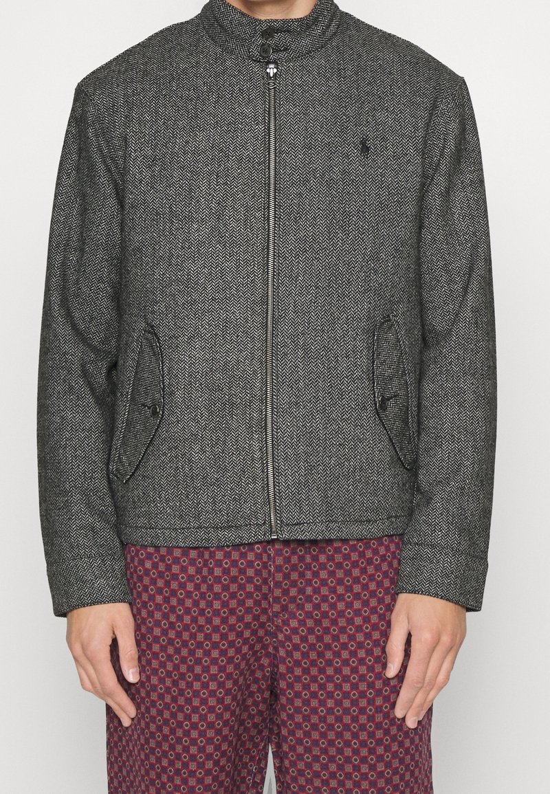 Šedý saka s rybím vzorem, stojáčkovým límcem, předním zipem, dvěma bočními kapsami a černými švovými detaily; kombinováno s vzorovanými vínovými kalhotami.