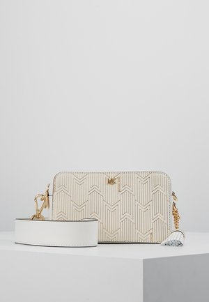 Crème- en goudkleurige rechthoekige crossbodytas met afneembare brede band en goudkleurige hardware op een witte ondergrond.