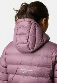 Lilla isoleret jakke med en fyldig design, der har en høj krave og et logo på bagsiden. Materialet har en glat, skinnende tekstur.