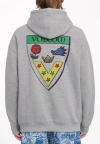 Grijze hoodie met een grote, kleurrijke graphic op de achterkant met een schildontwerp, inclusief een rode roos, een blauwe wilde zwijn, een gele V-vorm en vijf sterren.