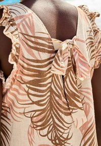 Leichtes Kleid aus Fabric mit einem braun-rosa Palmblätter-Muster, das Rüschensleeves und ein gebundenes Detail im Rücken aufweist.