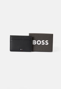 Portafoglio BOSS in pelle nera con più scomparti, texture liscia, logo discreto e una scatola di cartone con la scritta "BOSS" in lettere bianche in grassetto.