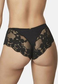 Culotte en dentelle noire avec des motifs floraux et un ourlet festonné, dotée d'un dos lisse et d'un petit logo doré.