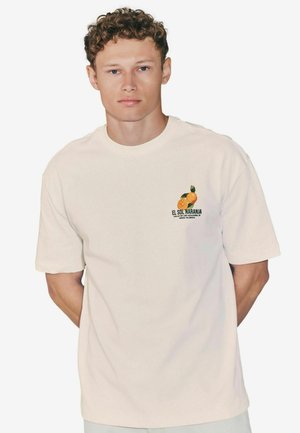 Light beige short-sleeve t-shirt made of cotton, featuring a small graphic of oranges and text on the left chest area.
