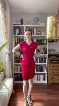 Figurbetontes, kurzärmeliges Kleid in leuchtendem Rot, mit gerafftem Design an der Brust und einer eleganten Silhouette. Kombiniert mit gemusterten Sneakers.