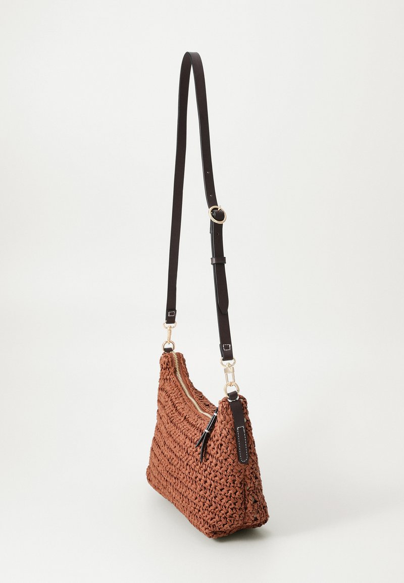 Bolso de mano de color marrón tejido con una textura desigual, diseño delgado, cremallera dorada y una correa ajustable de color marrón oscuro unida a herrajes dorados.