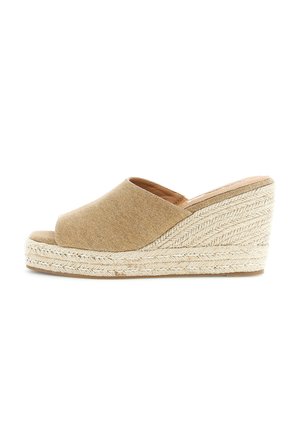 Sandalo a zeppa in tessuto beige con punta aperta e suola piattaforma in juta intrecciata su sfondo bianco.